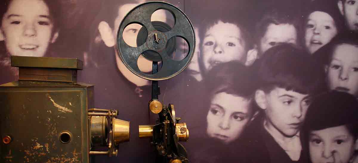 Old cinema reel camera with background photo of children