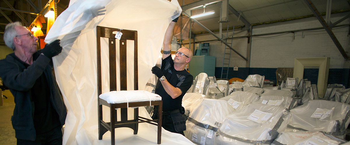Technicians wrap a Mackintosh chair in preparation for the move to Kelvin Hall