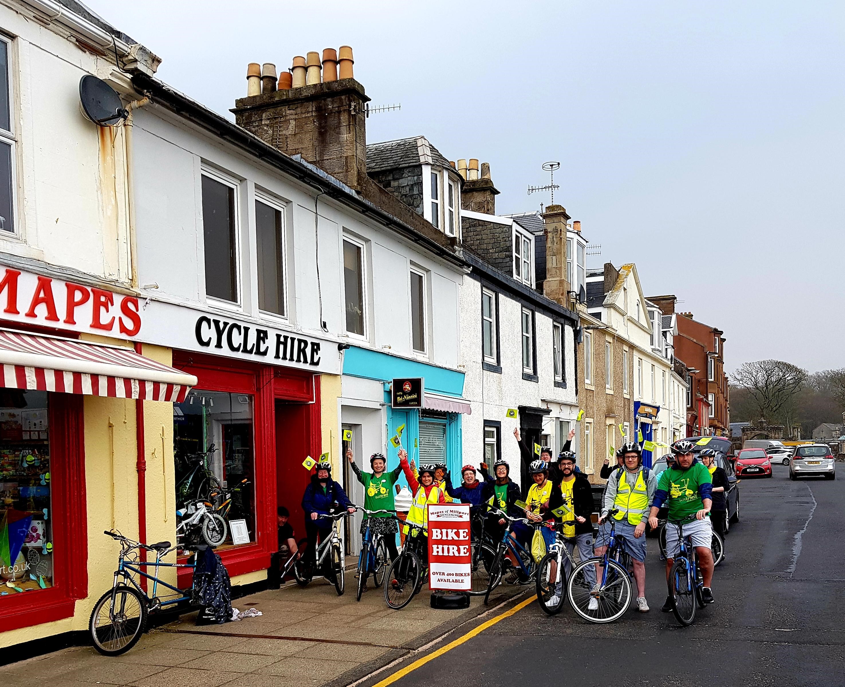 Group of people on bikes outside cycle hire shop on Milport 